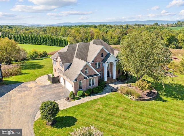 aerial view of property and surrounding area featuring a heavily wooded area