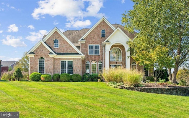 view of front of house featuring a front lawn and brick siding