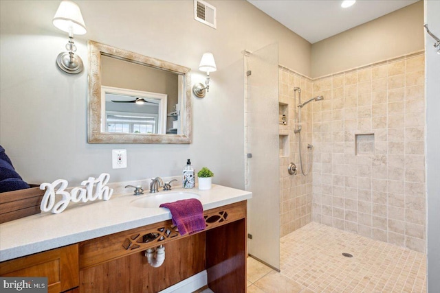 full bathroom featuring a tile shower, vanity, and tile patterned floors