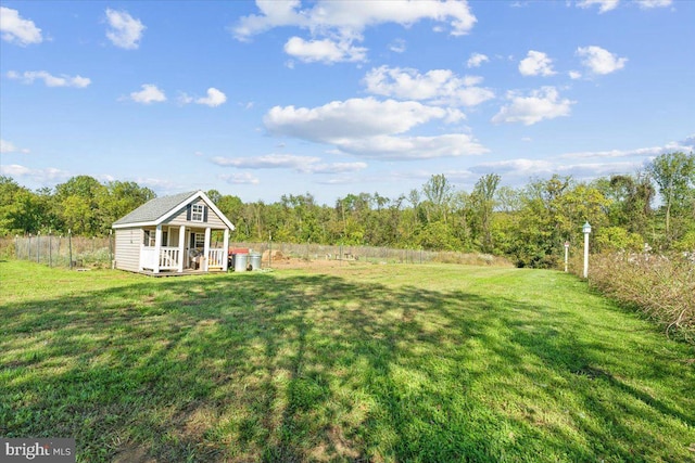 view of yard with covered porch and a wooded view