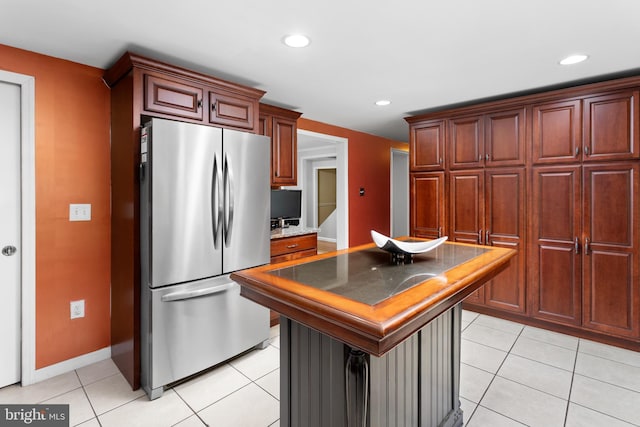 kitchen with freestanding refrigerator, light tile patterned floors, baseboards, recessed lighting, and a kitchen island