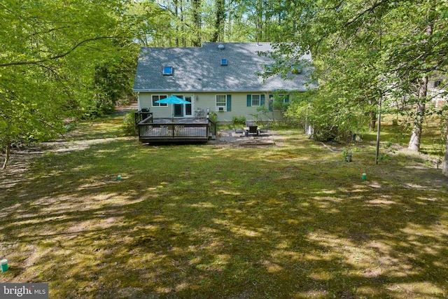 rear view of property featuring a deck, a yard, and a patio