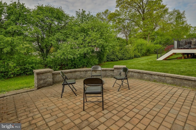 view of patio / terrace with a wooden deck, stairway, and view of wooded area