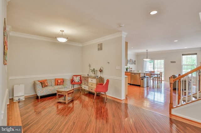 living area featuring light wood-style floors, crown molding, recessed lighting, stairs, and baseboards