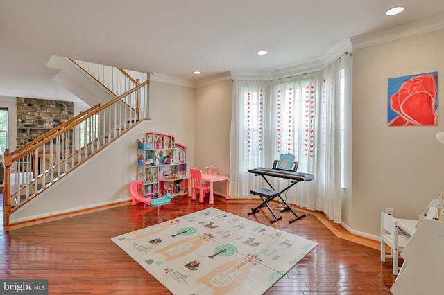 game room with baseboards, wood finished floors, ornamental molding, and recessed lighting