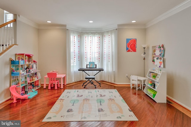 playroom with wood finished floors, crown molding, recessed lighting, and baseboards
