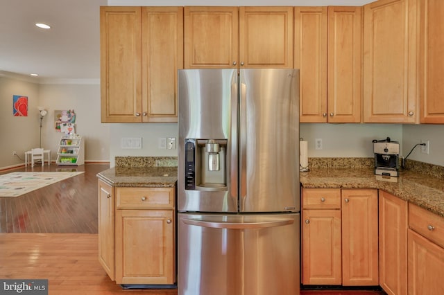 kitchen with stainless steel fridge with ice dispenser, light wood-style floors, ornamental molding, recessed lighting, and light stone counters