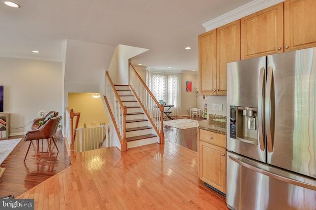 kitchen with stainless steel fridge with ice dispenser, light wood-style floors, recessed lighting, baseboards, and stone counters