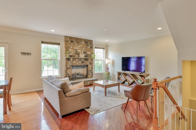 living area with light wood-style floors, crown molding, baseboards, recessed lighting, and a fireplace