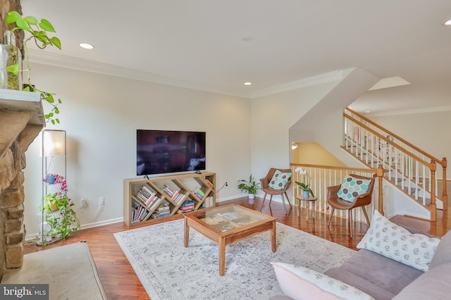 living area featuring crown molding, wood finished floors, baseboards, stairs, and recessed lighting