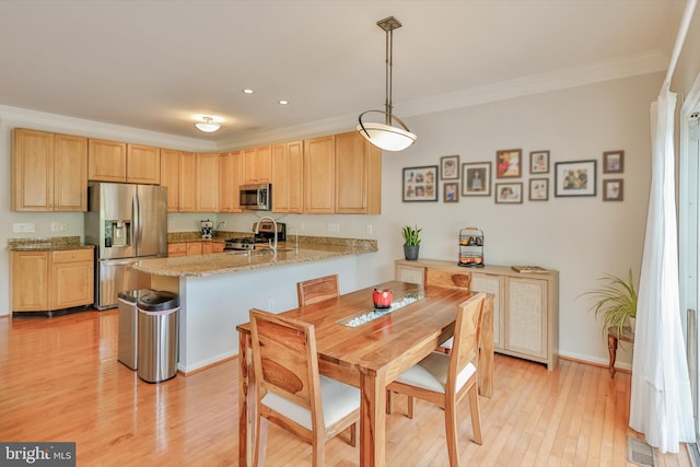 kitchen featuring appliances with stainless steel finishes, light brown cabinetry, a peninsula, ornamental molding, and recessed lighting