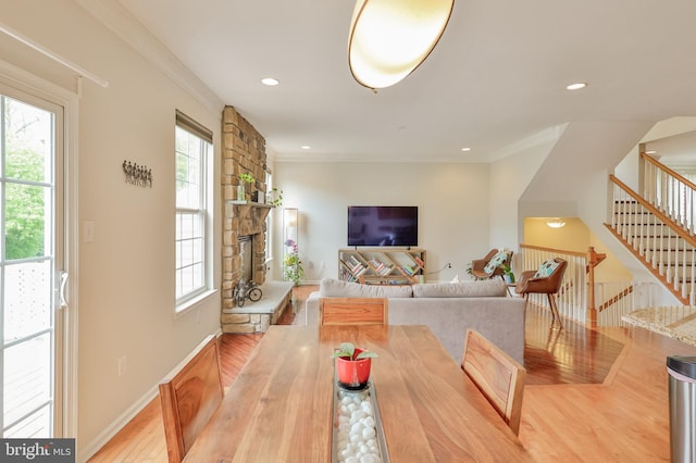 dining space featuring wood finished floors, plenty of natural light, stairway, crown molding, and recessed lighting