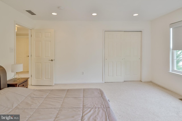 unfurnished bedroom featuring recessed lighting, carpet, and a closet