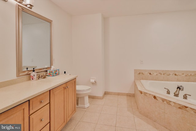 bathroom with tile patterned flooring, toilet, a garden tub, vanity, and baseboards