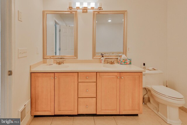 full bathroom with toilet, double vanity, and tile patterned flooring