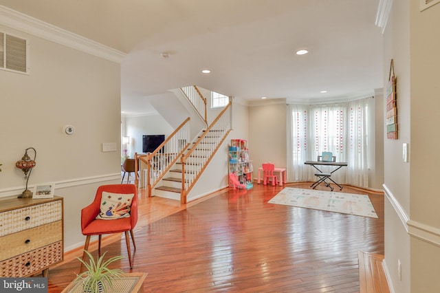 recreation room with ornamental molding, wood-type flooring, baseboards, and recessed lighting