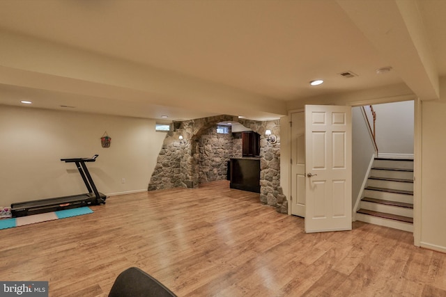 finished below grade area featuring wood finished floors, stairway, baseboards, and recessed lighting