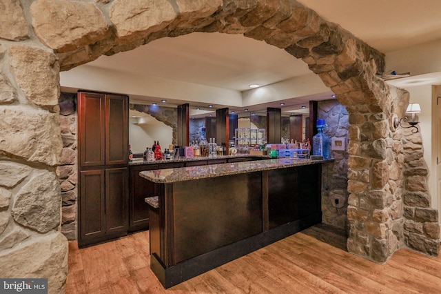 indoor bar featuring light wood-style flooring