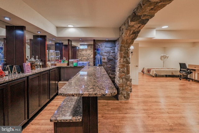 bar with light wood-type flooring and recessed lighting