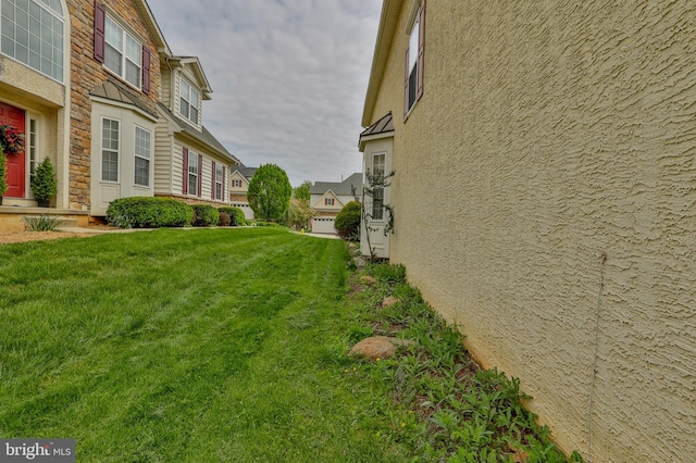 view of grassy yard with a residential view