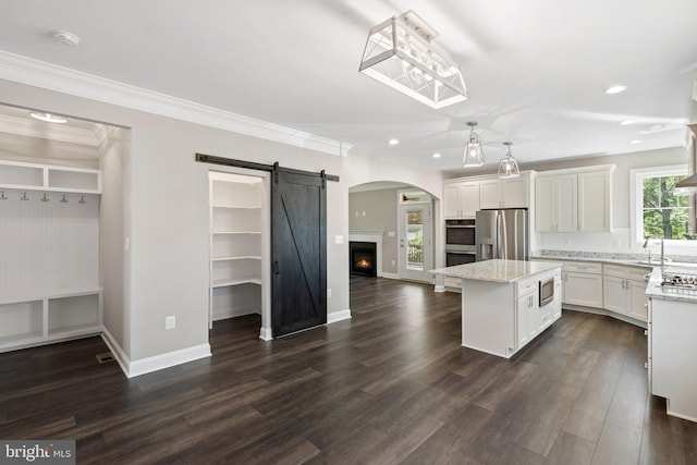 165 Green St, Warrenton, VA 20186 - kitchen featuring stainless steel appliances, a kitchen island, a sink, white cabinets, and light stone countertops
