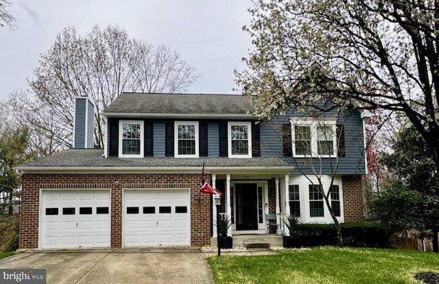traditional home with brick siding, driveway, a chimney, and an attached garage