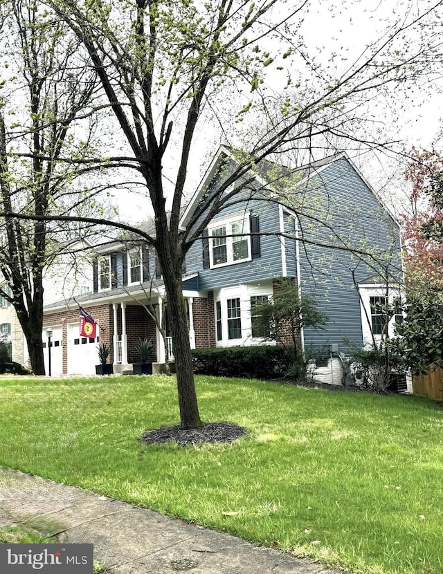 view of front of home featuring a front lawn and brick siding
