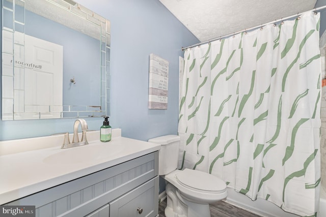 bathroom with a textured ceiling, toilet, vanity, wood finished floors, and shower / tub combo with curtain