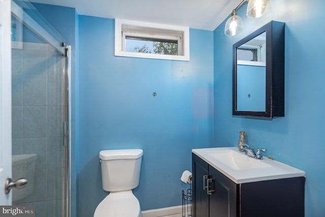 bathroom featuring toilet, vanity, and tiled shower