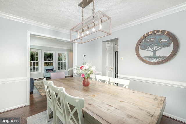 dining room with a chandelier, dark wood-style floors, a textured ceiling, baseboards, and crown molding