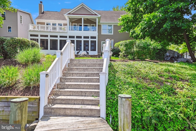 853 Imperial Rd, Arnold, MD 21012 - back of house with stairs, a sunroom, a balcony, a shingled roof, and a chimney