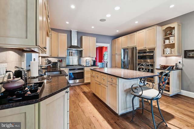 853 Imperial Rd, Arnold, MD 21012 - kitchen with stainless steel appliances, wall chimney range hood, a kitchen breakfast bar, wood finished floors, and tasteful backsplash