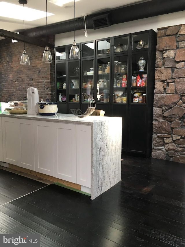 bar area with dark wood-style flooring and decorative light fixtures