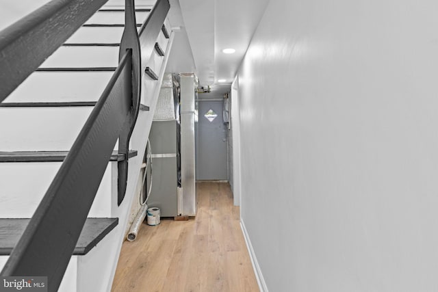corridor with wood finished floors, recessed lighting, and baseboards