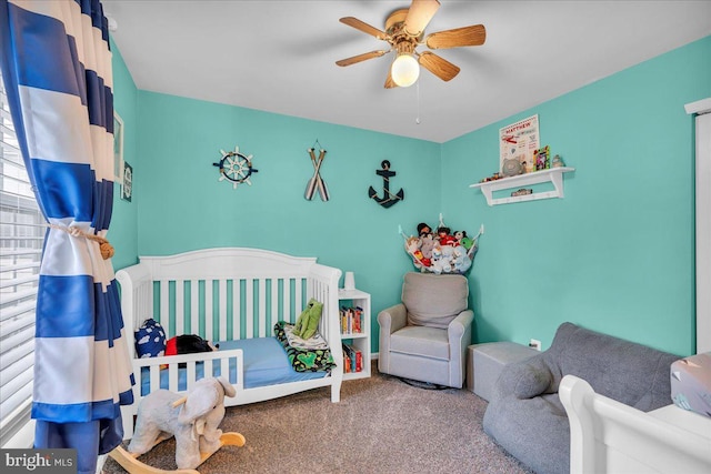 carpeted bedroom with a ceiling fan and a nursery area