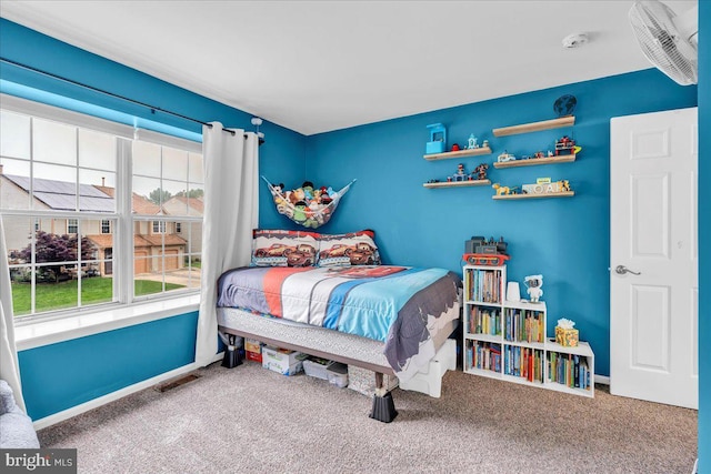 carpeted bedroom with multiple windows and baseboards