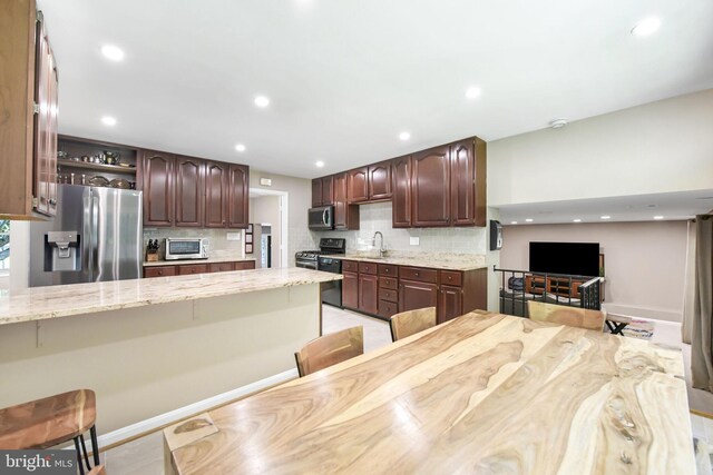 kitchen with appliances with stainless steel finishes, decorative backsplash, open shelves, recessed lighting, and light stone countertops