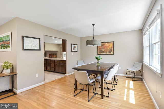 dining area featuring light wood finished floors and baseboards