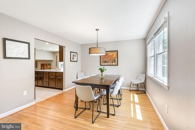 dining area featuring light wood finished floors and baseboards
