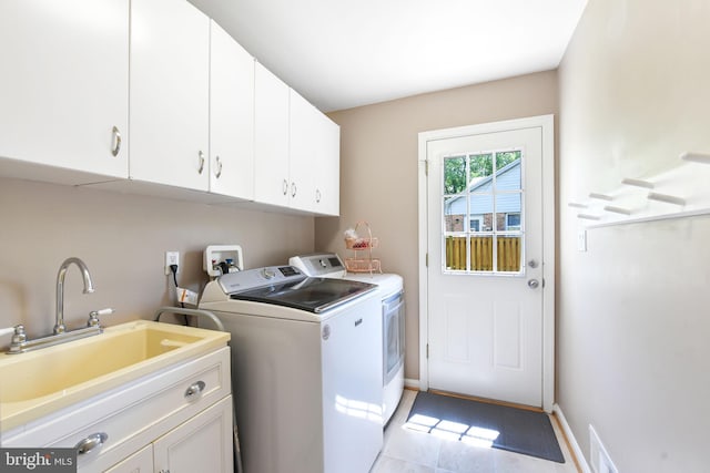 laundry area featuring independent washer and dryer, cabinet space, baseboards, and light tile patterned flooring