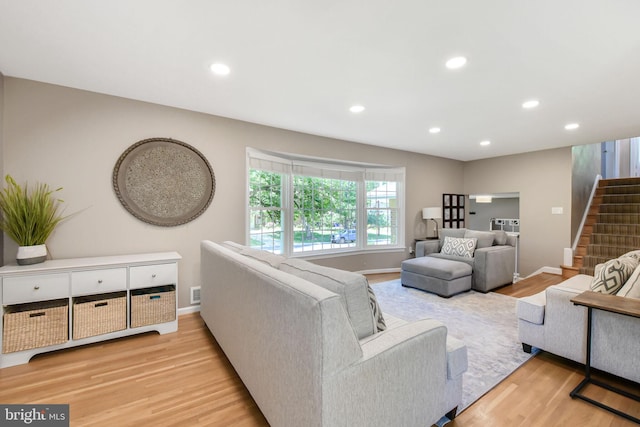 living area featuring stairway, light wood-type flooring, recessed lighting, and baseboards