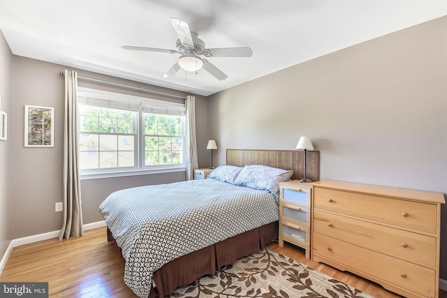bedroom featuring light wood finished floors, baseboards, and a ceiling fan