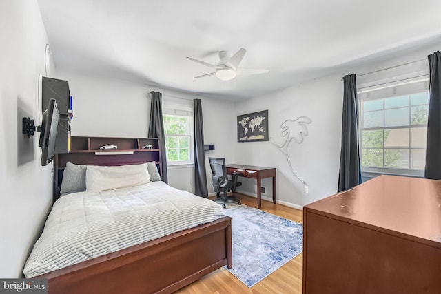 bedroom featuring light wood finished floors, ceiling fan, and baseboards