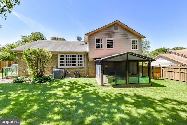 rear view of property featuring a sunroom, brick siding, and central AC unit