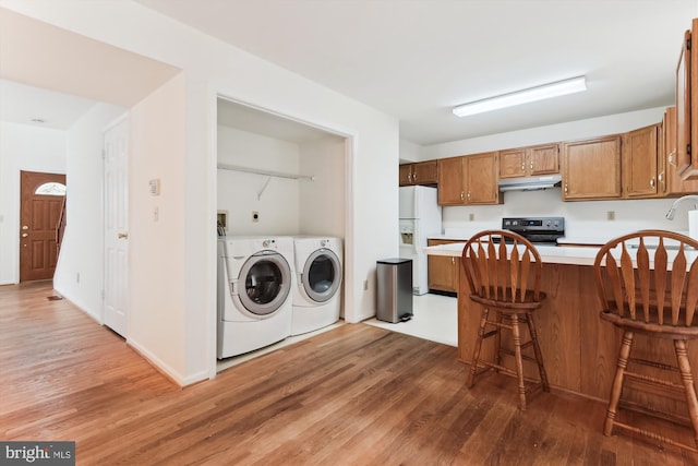 389 Mattapany Ct, Arnold, MD 21012 - kitchen featuring washing machine and dryer, white refrigerator with ice dispenser, stainless steel electric range, wood finished floors, and under cabinet range hood