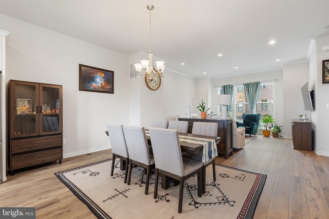 dining area featuring light wood-type flooring, a chandelier, crown molding, baseboards, and recessed lighting