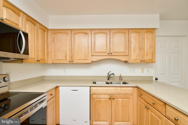 kitchen featuring stainless steel appliances, a sink, light brown cabinets, and light countertops