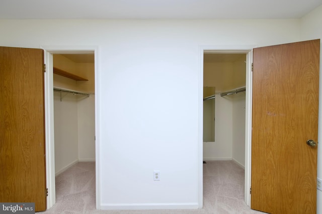 unfurnished bedroom featuring a walk in closet, carpet flooring, and a closet