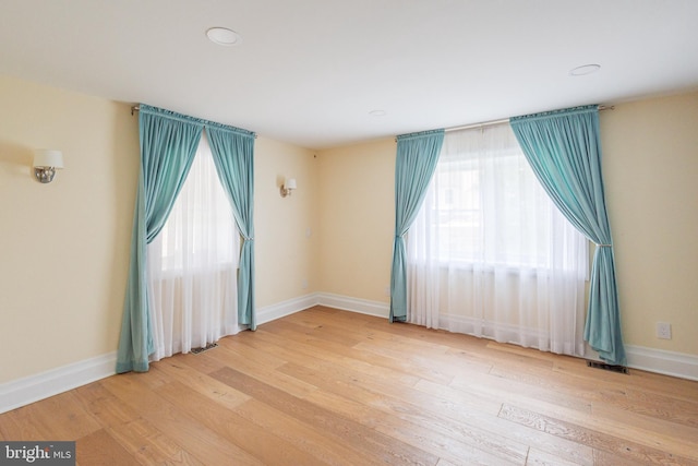 spare room featuring wood finished floors, baseboards, and recessed lighting
