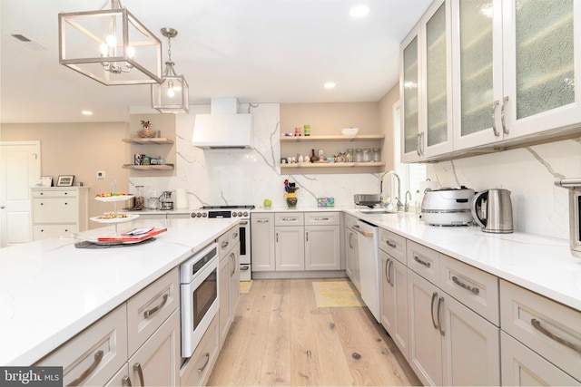 kitchen with open shelves, a sink, high end stove, built in microwave, and premium range hood